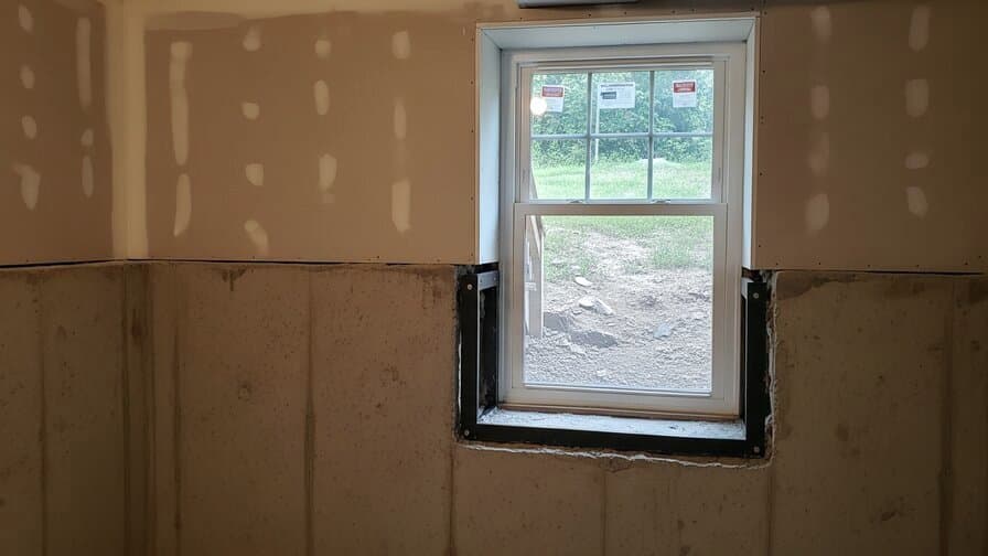 Columbus Ohio Franklin County vinyl window sash crack repair contractor applying two-part structural epoxy into freeze-thaw corner weld crack at 90-degree sash frame corner junction on residential vinyl window showing contractor with epoxy applicator sealing corner weld hairline crack with Columbus Ohio Worthington residential neighborhood background